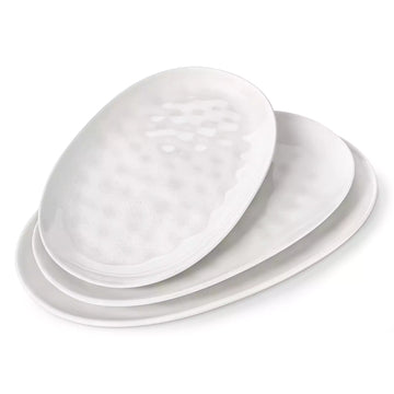 Three TARA white speckled stoneware oval serving platters stacked in graduated sizes.