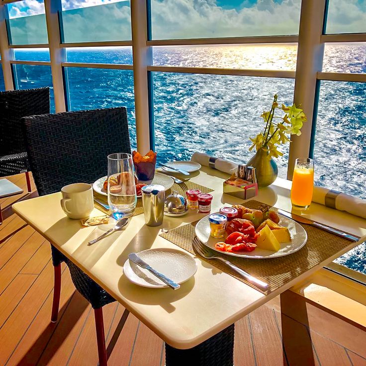 Cruise ship breakfast table with fruit, pastries, coffee, orange juice, and ocean views
