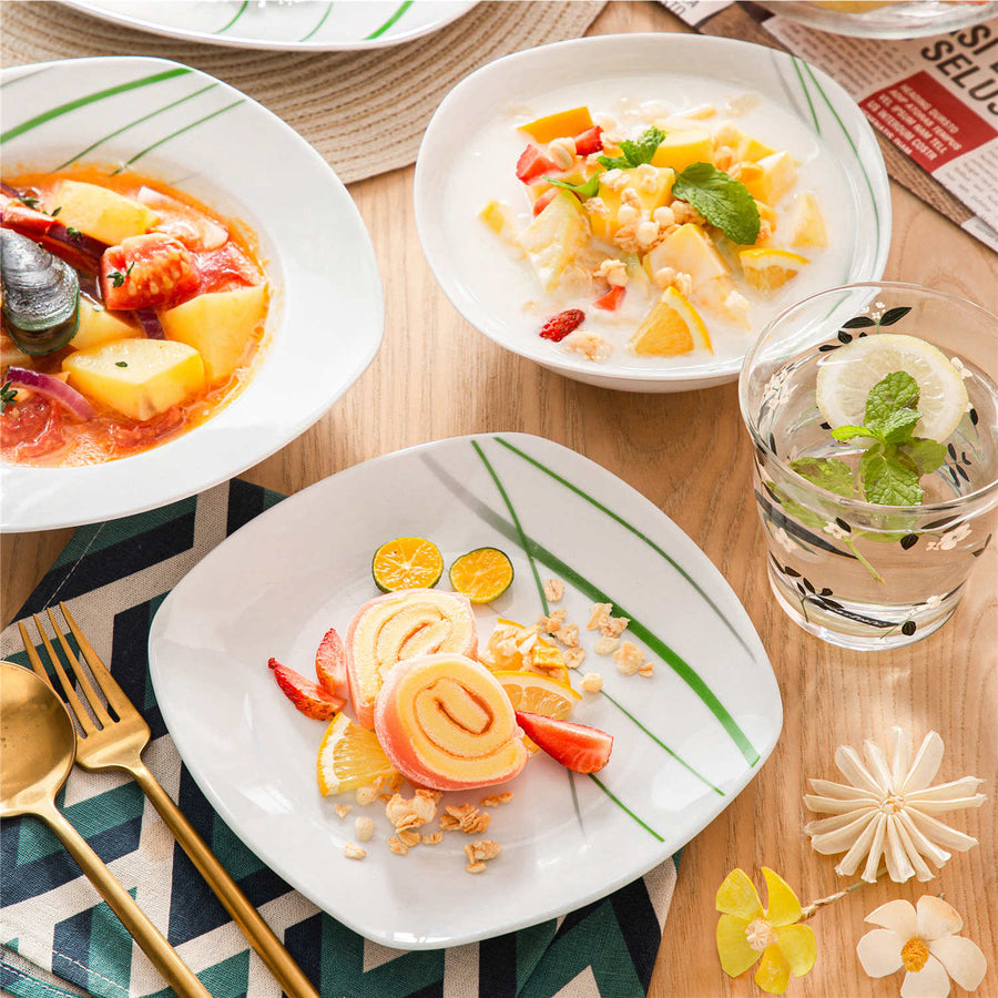 Aviva series dinnerware set featuring seafood soup, fruit salad, and swiss roll cake on white plates with green accents