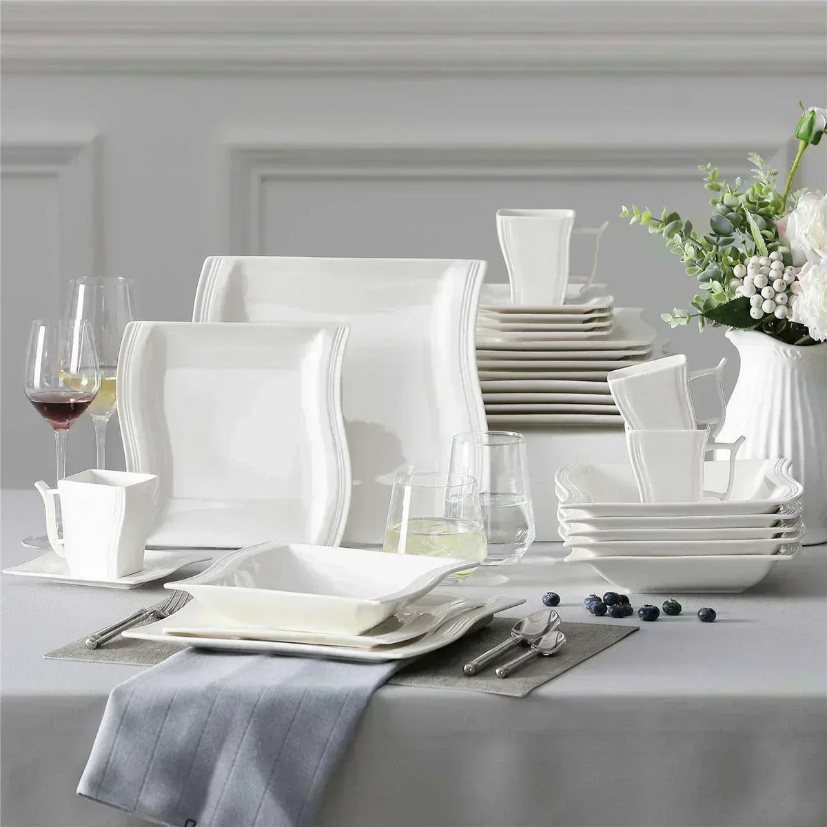 Square dinnerware sets neatly stacked inside a small kitchen cabinet to show space-saving storage and organized cabinet layout.