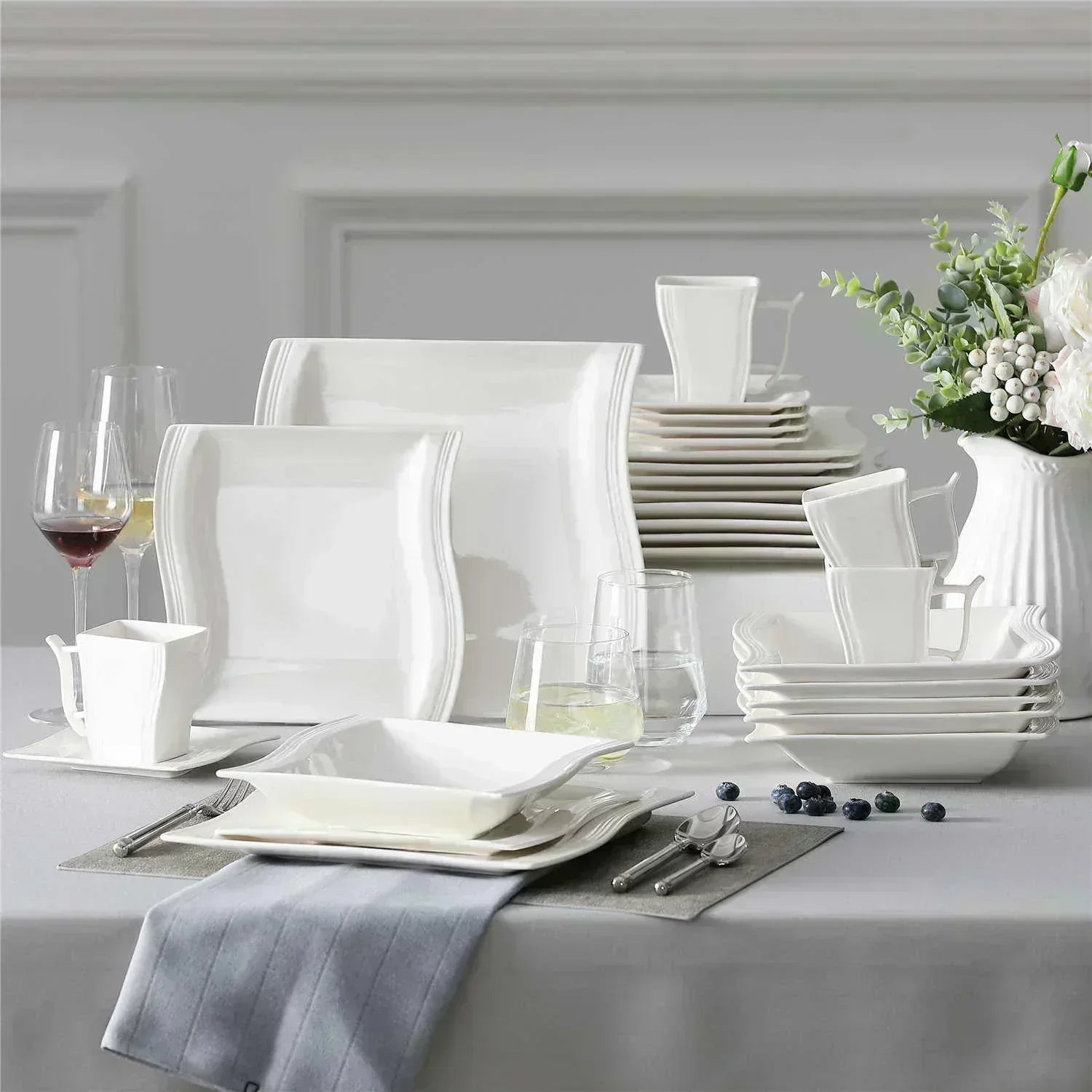 Square dinnerware sets neatly stacked inside a small kitchen cabinet to show space-saving storage and organized cabinet layout.