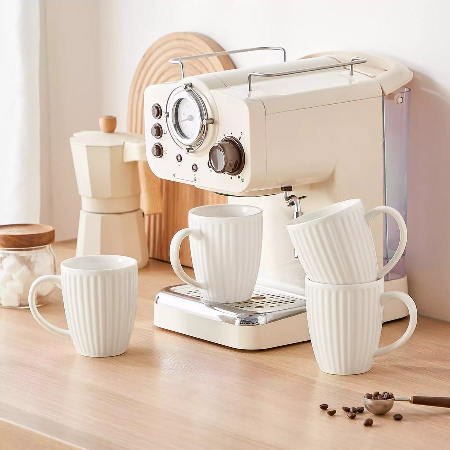 Stackable white coffee mugs neatly arranged beside a mug tree stand in a modern kitchen