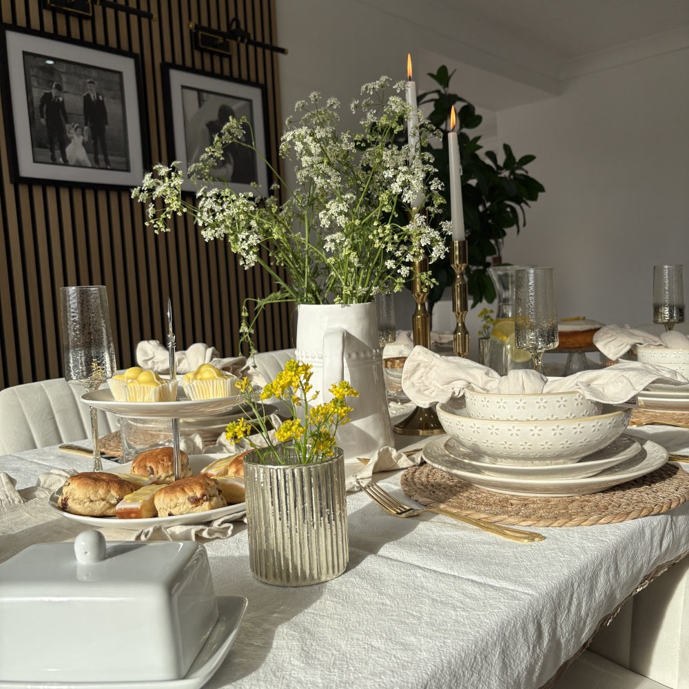Vintage French-style table setting featuring stoneware dinnerware, soft linens, and elegant plating