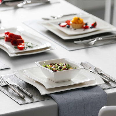 MALACASA Flora 30-piece white porcelain dinnerware set displayed on a modern dining table with appetizers and salad.