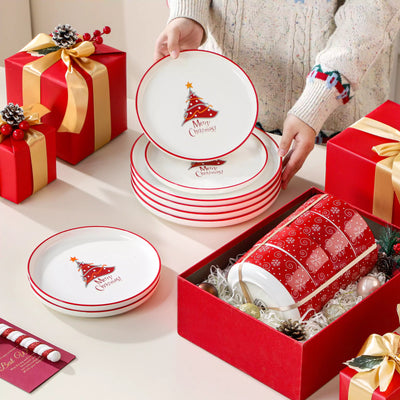 12-piece porcelain dinnerware set from the Christmas Collection, featuring a red Christmas tree topped with a gold star and surrounded by delicate snowflakes; includes plates and bowls for four.