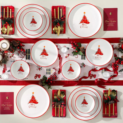 12-piece porcelain dinnerware set from the Christmas Collection, featuring a red Christmas tree topped with a gold star and surrounded by delicate snowflakes; includes plates and bowls for four.