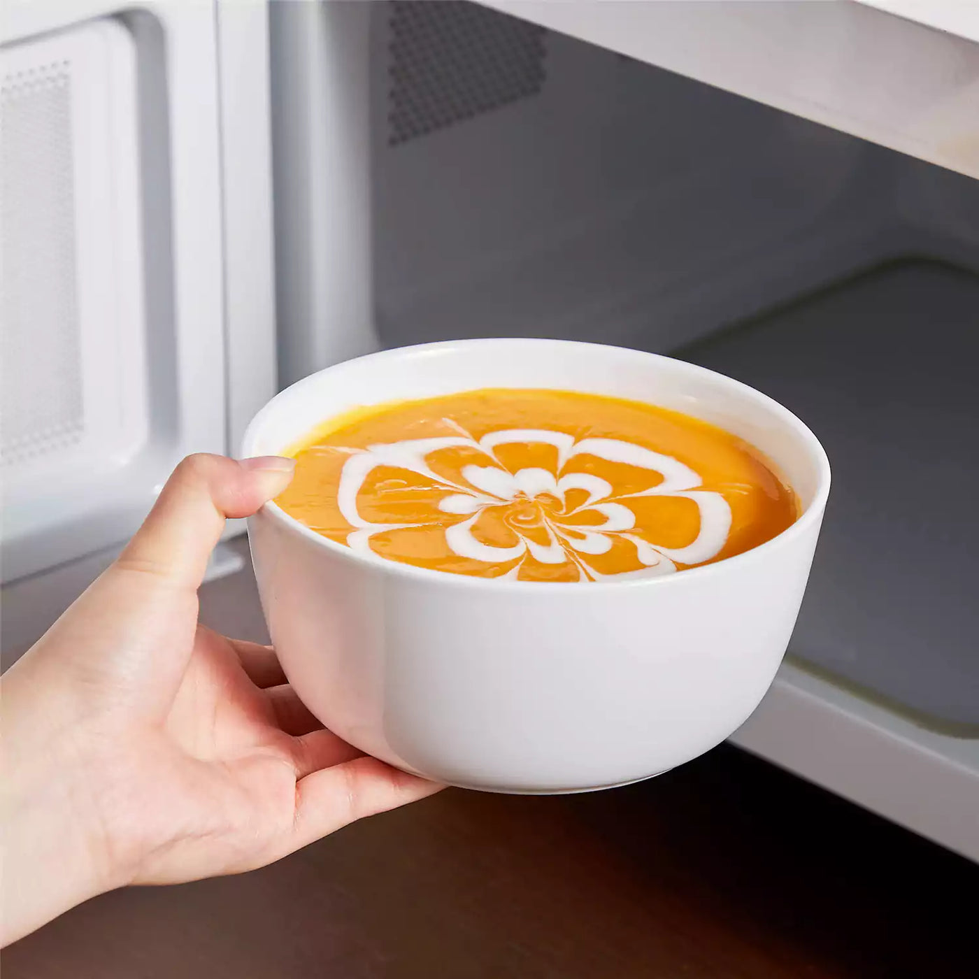 LEXI off-white porcelain dinnerware set including arc-shaped plates with lifted rims and deep rounded bowls#color_white