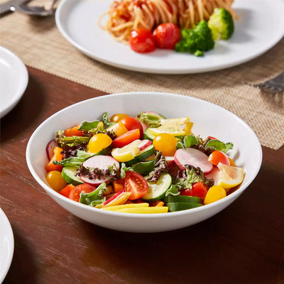 LEXI off-white porcelain dinnerware set including arc-shaped plates with lifted rims and deep rounded bowls#color_white