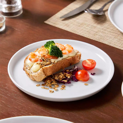 LEXI off-white porcelain dinnerware set including arc-shaped plates with lifted rims and deep rounded bowls#color_white