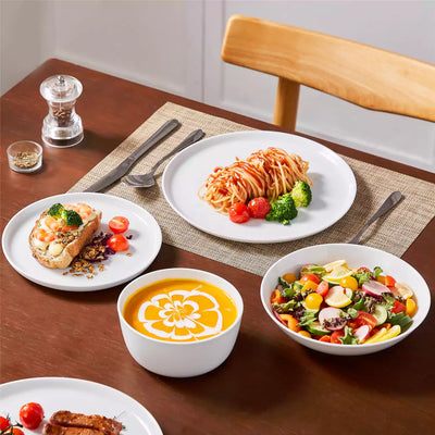 LEXI off-white porcelain dinnerware set including arc-shaped plates with lifted rims and deep rounded bowls#color_white