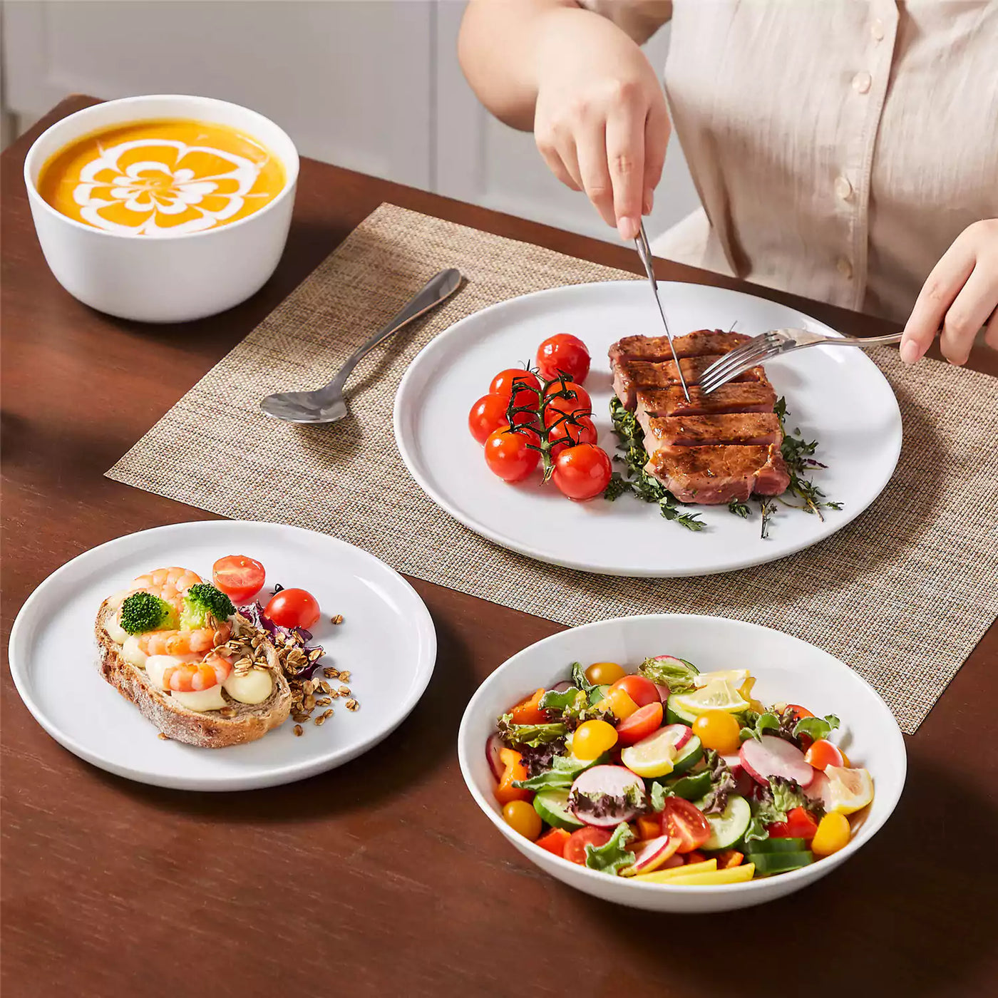 LEXI off-white porcelain dinnerware set including arc-shaped plates with lifted rims and deep rounded bowls#color_white