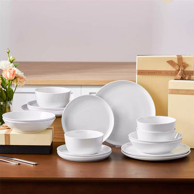 LEXI off-white porcelain dinnerware set including arc-shaped plates with lifted rims and deep rounded bowls#color_white