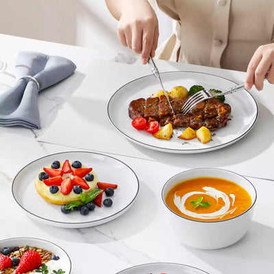 LEXI off-white porcelain dinnerware set including arc-shaped plates with lifted rims and deep rounded bowls#color_black-trim