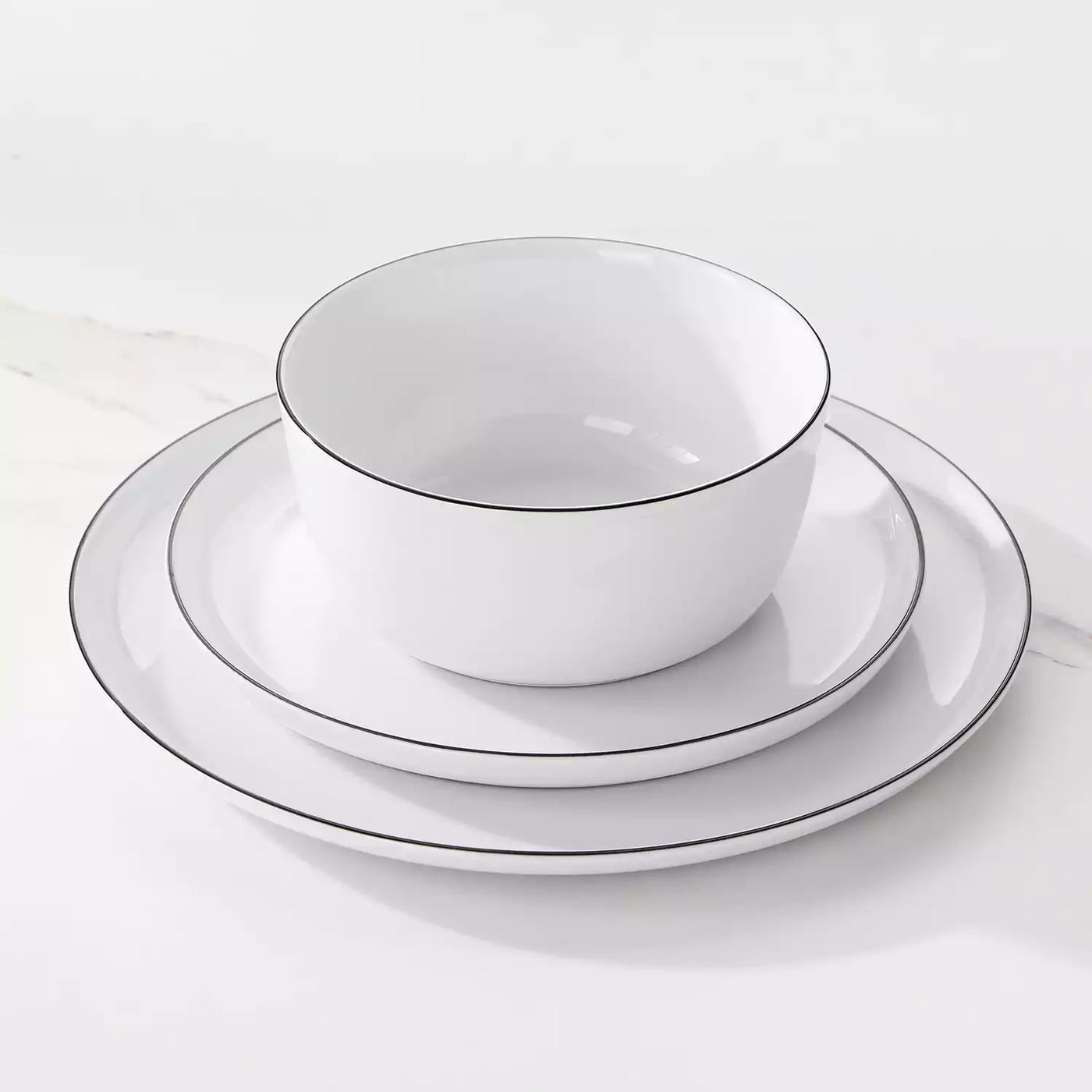 LEXI off-white porcelain dinnerware set including arc-shaped plates with lifted rims and deep rounded bowls#color_black-trim