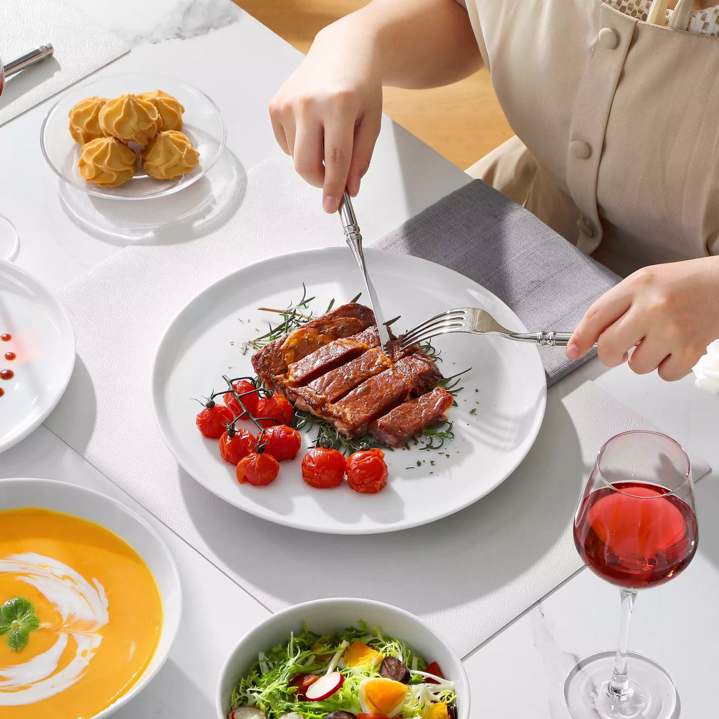 LEXI off-white porcelain dinnerware set including arc-shaped plates with lifted rims and deep rounded bowls#color_white