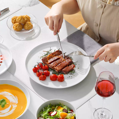 LEXI off-white porcelain dinnerware set including arc-shaped plates with lifted rims and deep rounded bowls#color_white