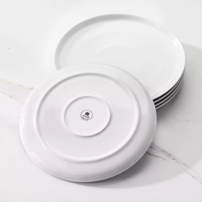 LEXI off-white porcelain dinnerware set including arc-shaped plates with lifted rims and deep rounded bowls#color_white