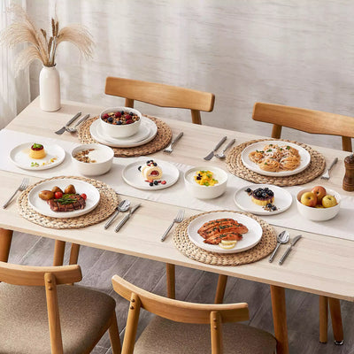MINA porcelain dinnerware set featuring curved-edge plates and bowls with lifted rims.#color_ivory-white
