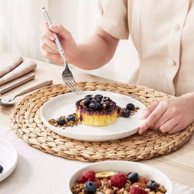 MINA porcelain dinnerware set featuring curved-edge plates and bowls with lifted rims.#color_ivory-white