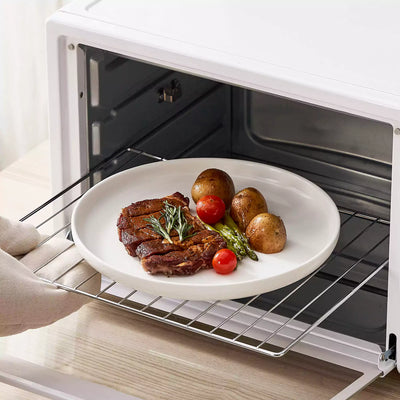 MINA porcelain dinnerware set featuring curved-edge plates and bowls with lifted rims.#color_ivory-white