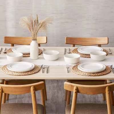 MINA porcelain dinnerware set featuring curved-edge plates and bowls with lifted rims.#color_ivory-white
