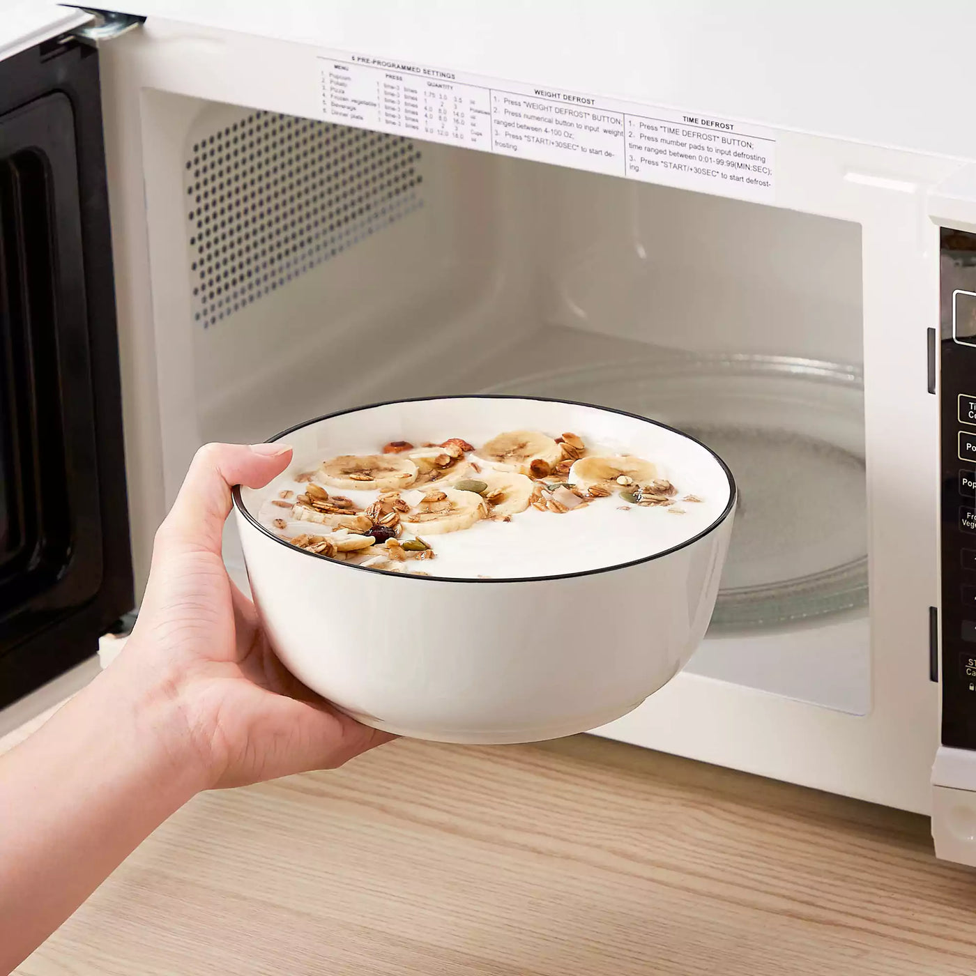 MINA porcelain dinnerware set featuring curved-edge plates and bowls with lifted rims#color_black-trim