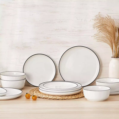 MINA porcelain dinnerware set featuring curved-edge plates and bowls with lifted rims#color_black-trim