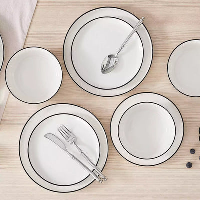 MINA porcelain dinnerware set featuring curved-edge plates and bowls with lifted rims#color_black-trim