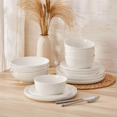 MINA porcelain dinnerware set featuring curved-edge plates and bowls with lifted rims.#color_ivory-white