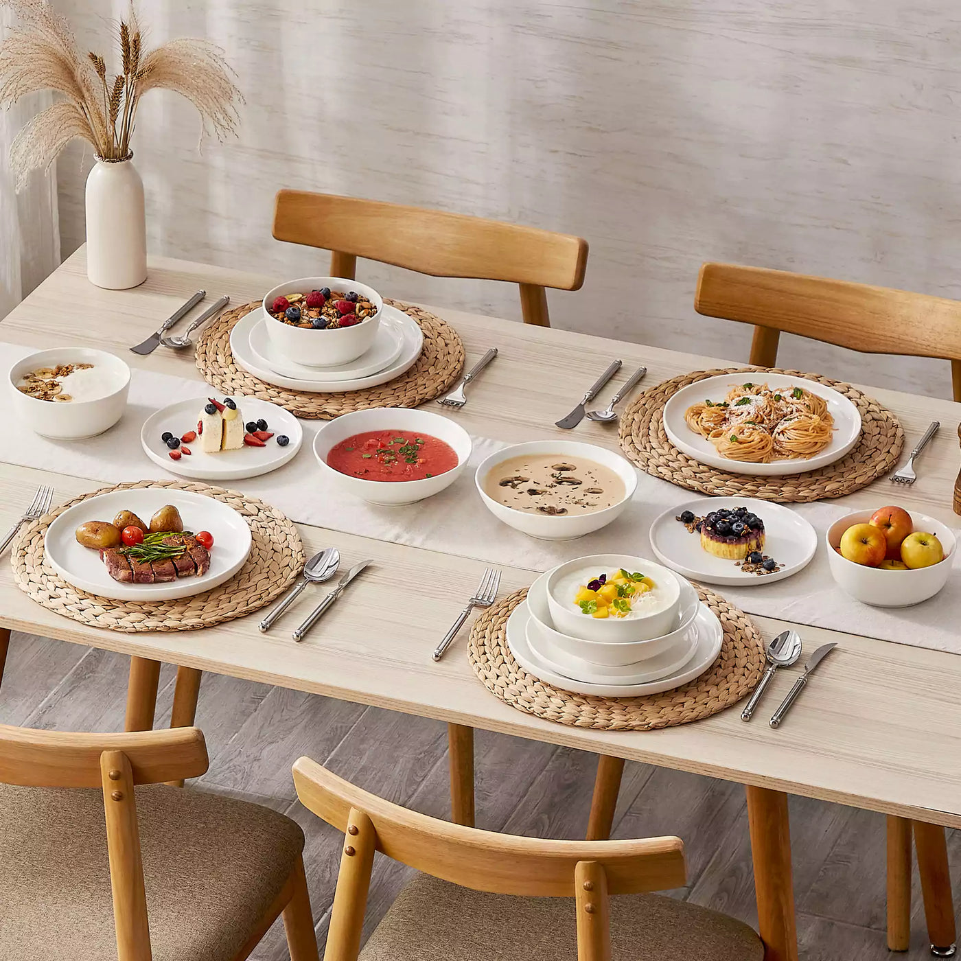 MINA porcelain dinnerware set featuring curved-edge plates and bowls with lifted rims.#color_ivory-white