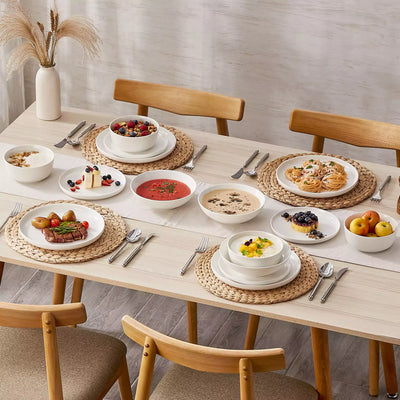 MINA porcelain dinnerware set featuring curved-edge plates and bowls with lifted rims.#color_ivory-white