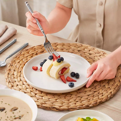 MINA porcelain dinnerware set featuring curved-edge plates and bowls with lifted rims.#color_ivory-white