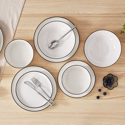 MINA porcelain dinnerware set featuring curved-edge plates and bowls with lifted rims#color_black-trim