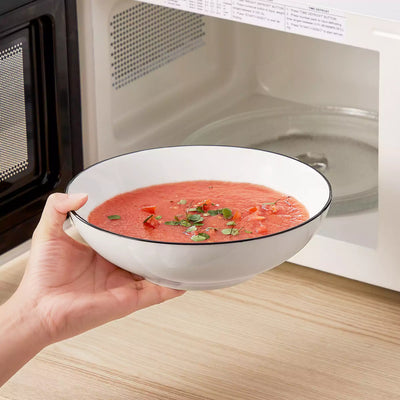 MINA porcelain dinnerware set featuring curved-edge plates and bowls with lifted rims#color_black-trim