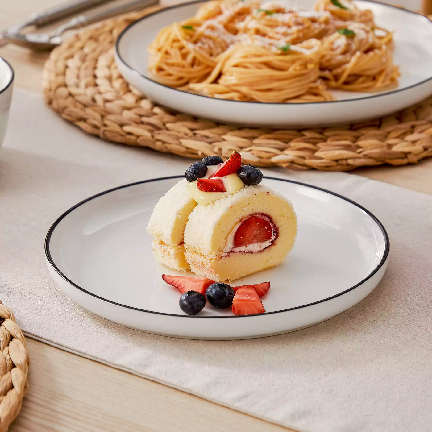 MINA porcelain dinnerware set featuring curved-edge plates and bowls with lifted rims#color_black-trim