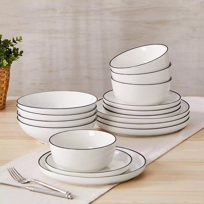 MINA porcelain dinnerware set featuring curved-edge plates and bowls with lifted rims#color_black-trim