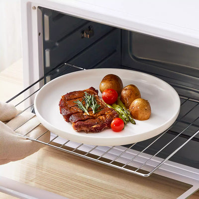 MINA porcelain dinnerware set featuring curved-edge plates and bowls with lifted rims.#color_ivory-white