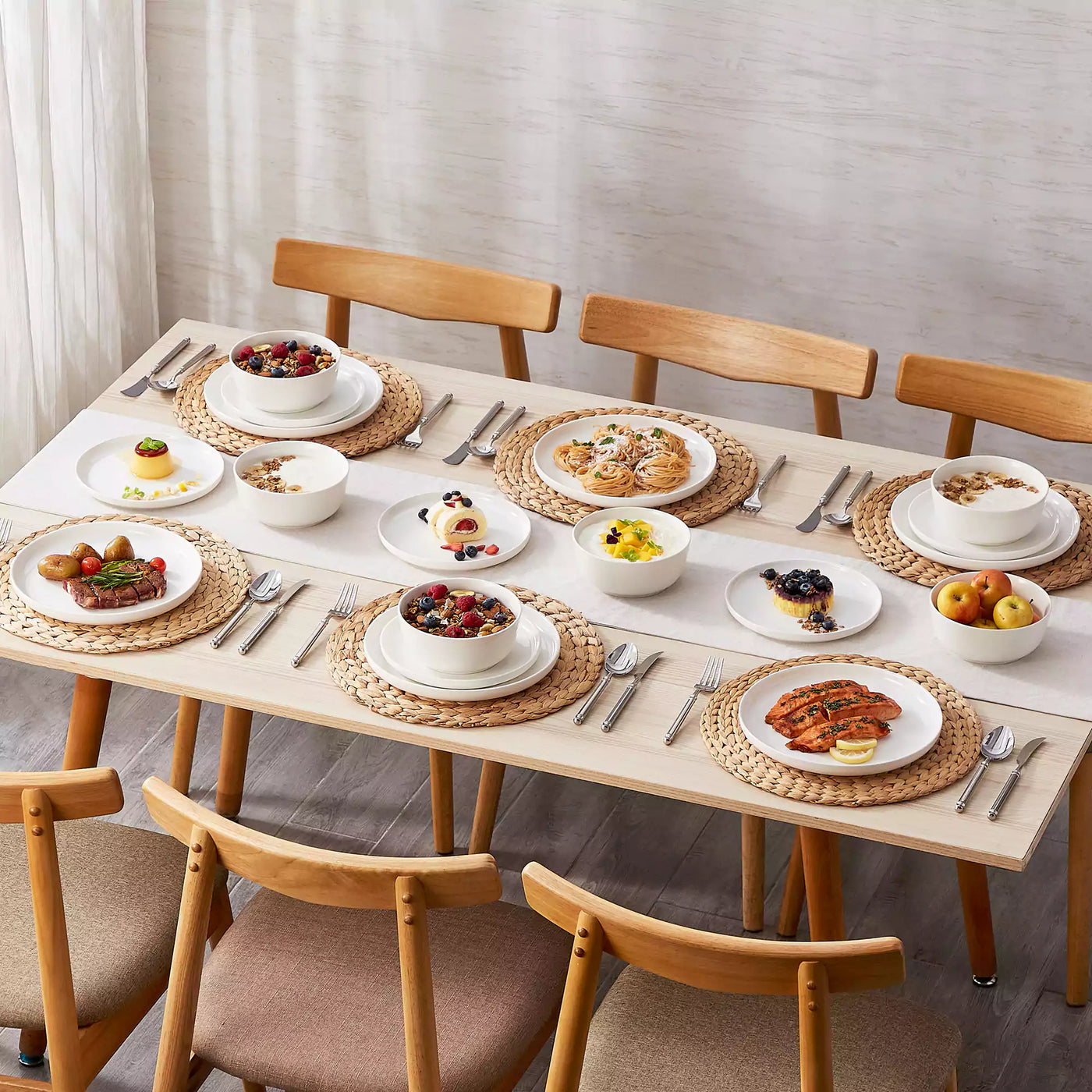 MINA porcelain dinnerware set featuring curved-edge plates and bowls with lifted rims.#color_ivory-white