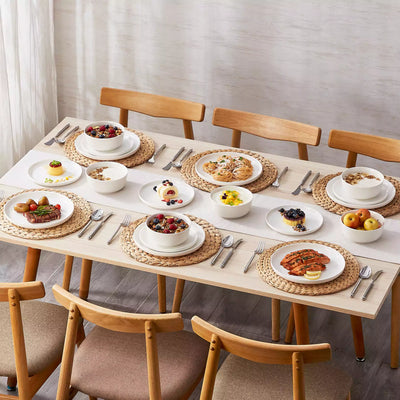 MINA porcelain dinnerware set featuring curved-edge plates and bowls with lifted rims.#color_ivory-white