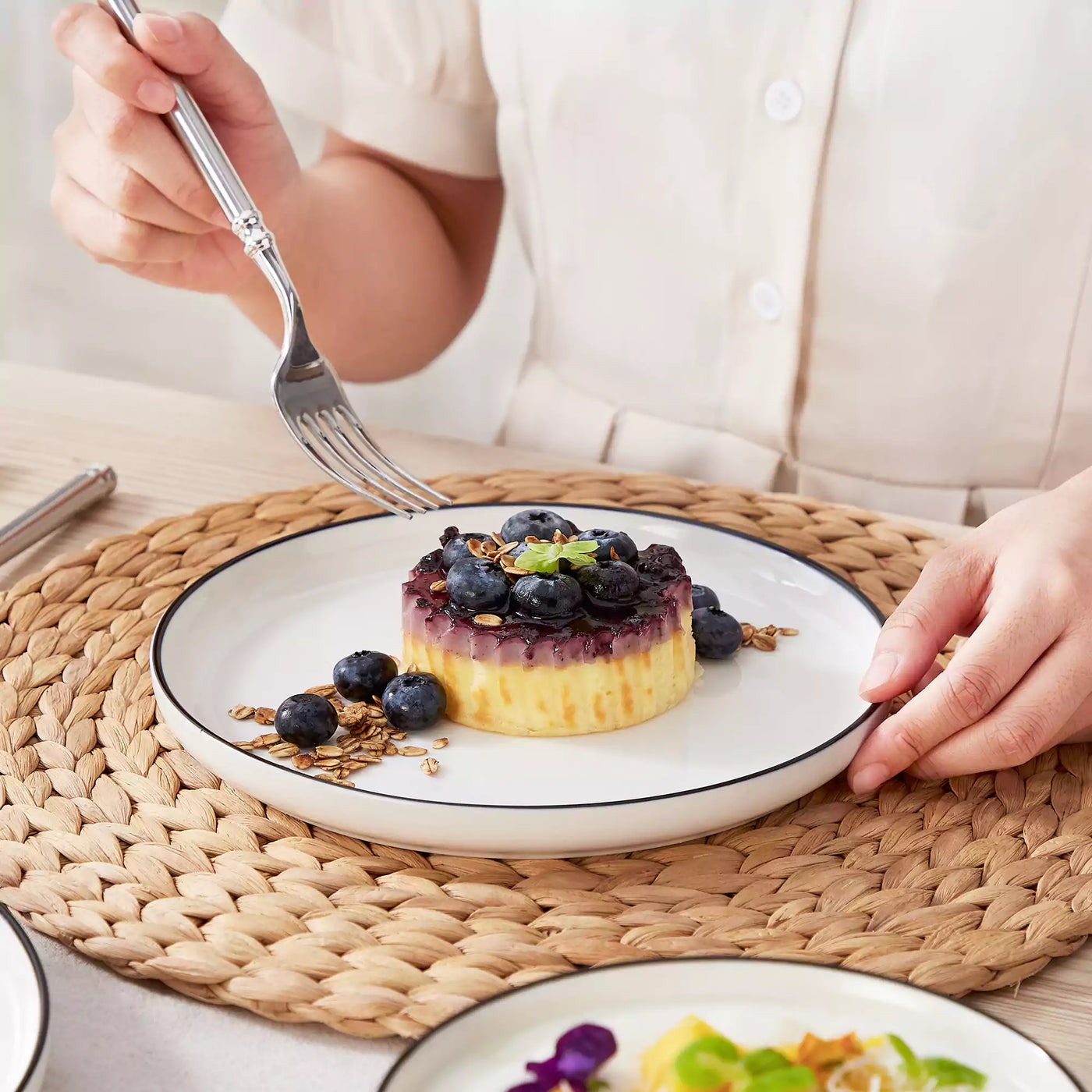 MINA porcelain dinnerware set featuring curved-edge plates and bowls with lifted rims#color_black-trim