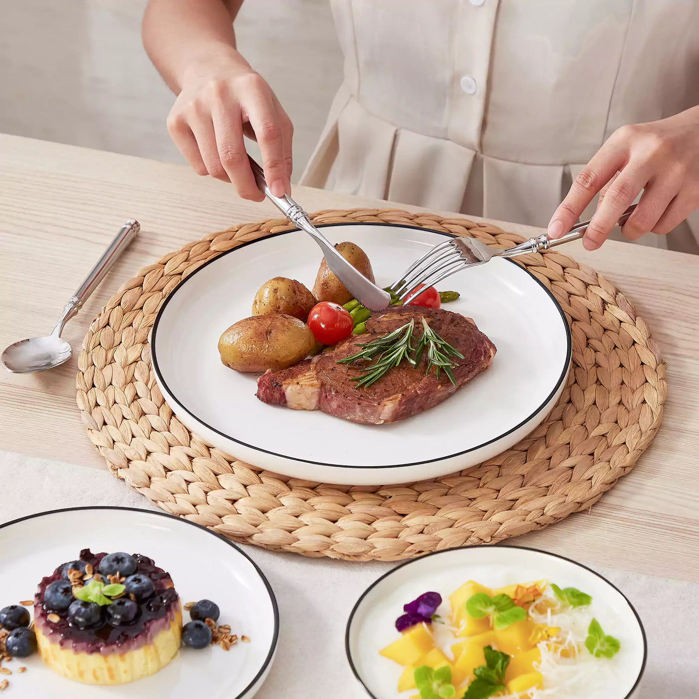 MINA porcelain dinnerware set featuring curved-edge plates and bowls with lifted rims#color_black-trim