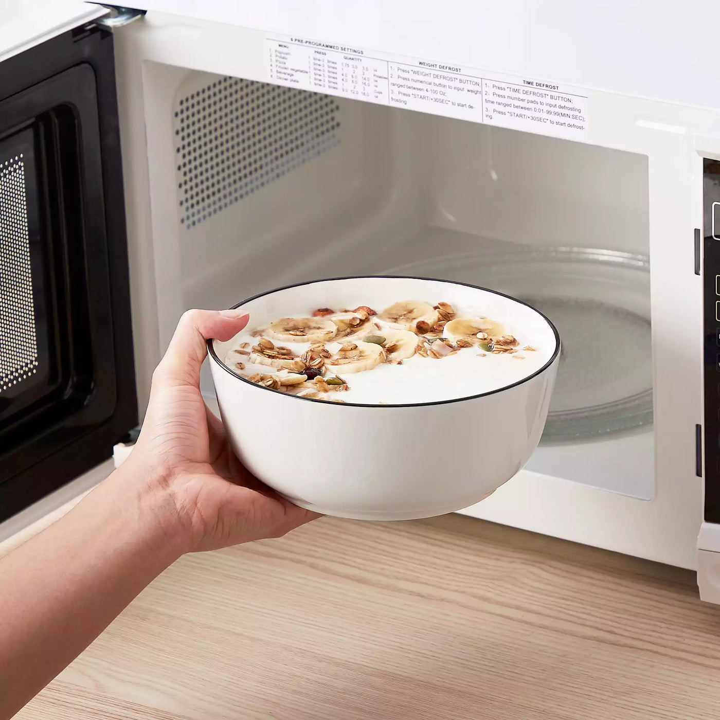 MINA porcelain dinnerware set featuring curved-edge plates and bowls with lifted rims#color_black-trim