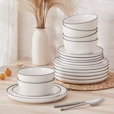 MINA porcelain dinnerware set featuring curved-edge plates and bowls with lifted rims#color_black-trim