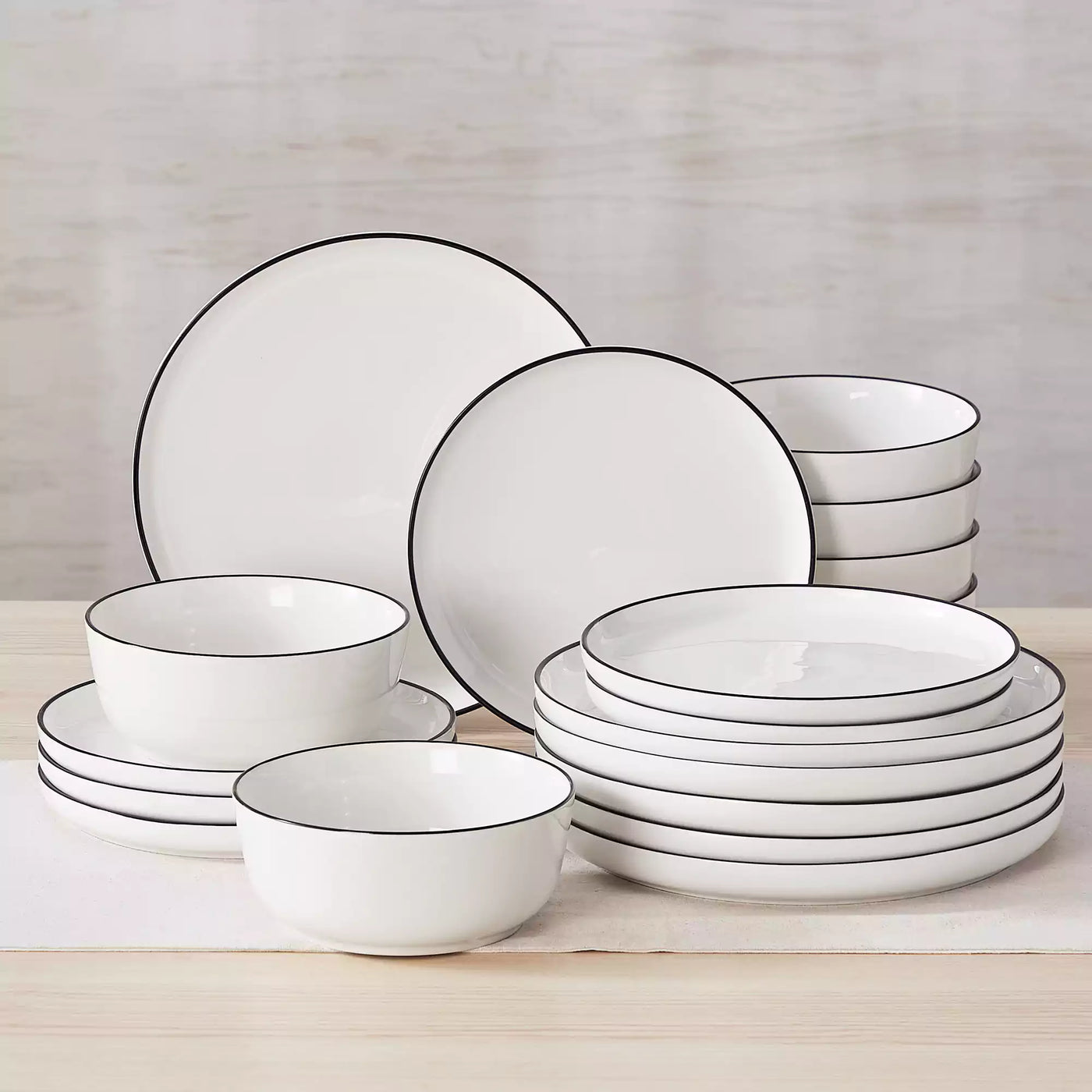 MINA porcelain dinnerware set featuring curved-edge plates and bowls with lifted rims#color_black-trim