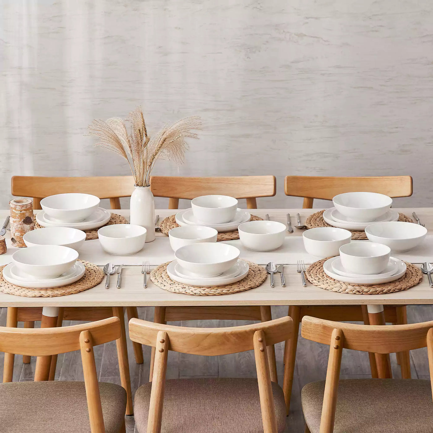 MINA porcelain dinnerware set featuring curved-edge plates and bowls with lifted rims.#color_ivory-white