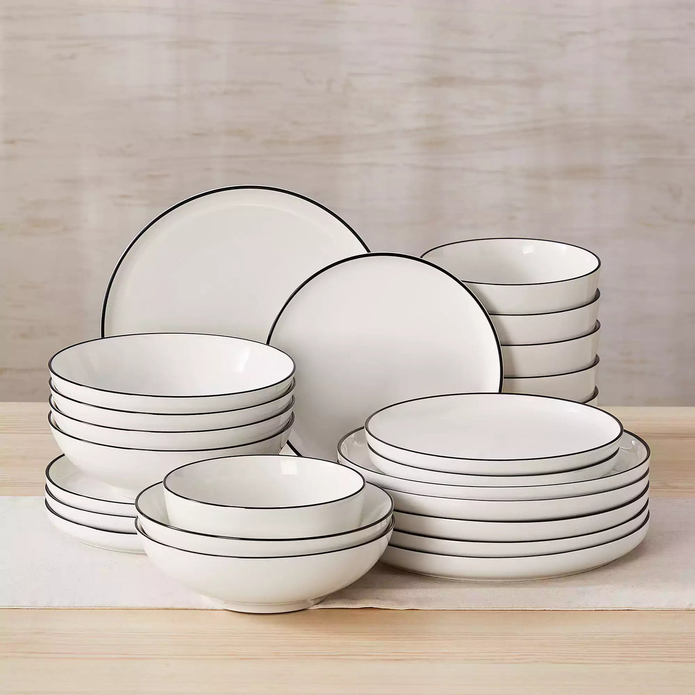 MINA porcelain dinnerware set featuring curved-edge plates and bowls with lifted rims#color_black-trim