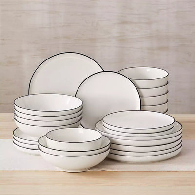 MINA porcelain dinnerware set featuring curved-edge plates and bowls with lifted rims#color_black-trim