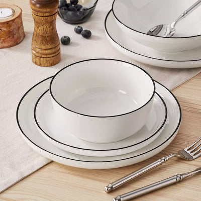 MINA porcelain dinnerware set featuring curved-edge plates and bowls with lifted rims#color_black-trim