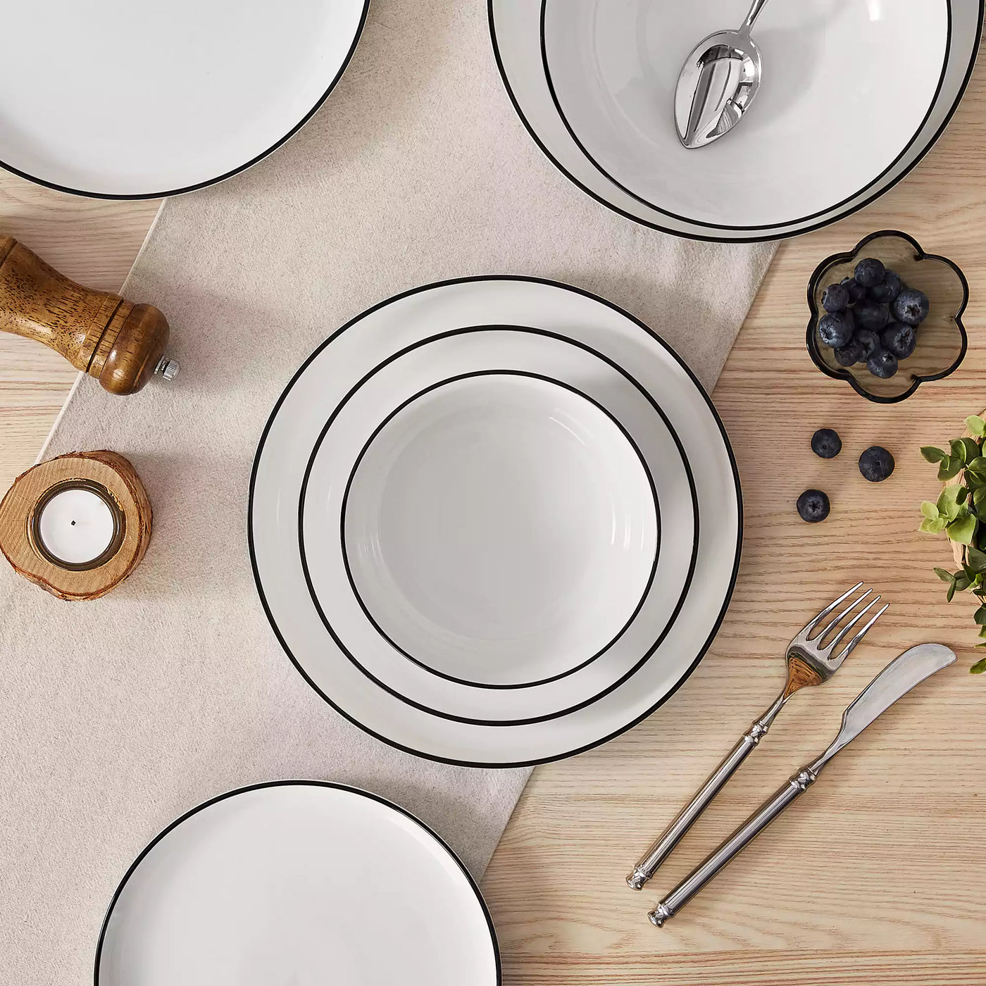 MINA porcelain dinnerware set featuring curved-edge plates and bowls with lifted rims#color_black-trim