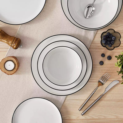 MINA porcelain dinnerware set featuring curved-edge plates and bowls with lifted rims#color_black-trim